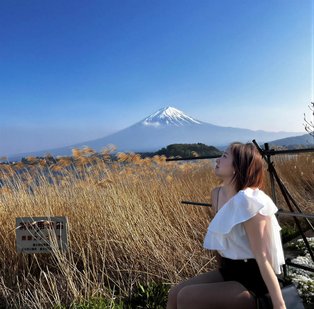 Alicia in profile before Mount Fuji and sunlit golden reeds