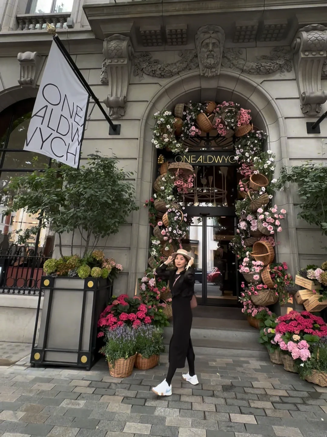 Alicia in a black dress outside a flower-filled London storefront